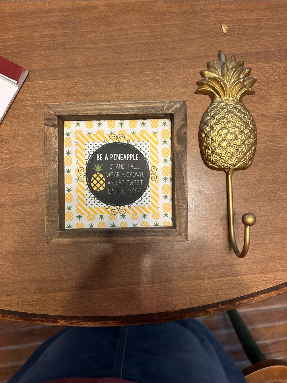 Gold Pineapple Hook which could be cast iron. A wood framed pineapple quote.